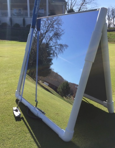 A golfer practicing a draw shot in front of a mirror