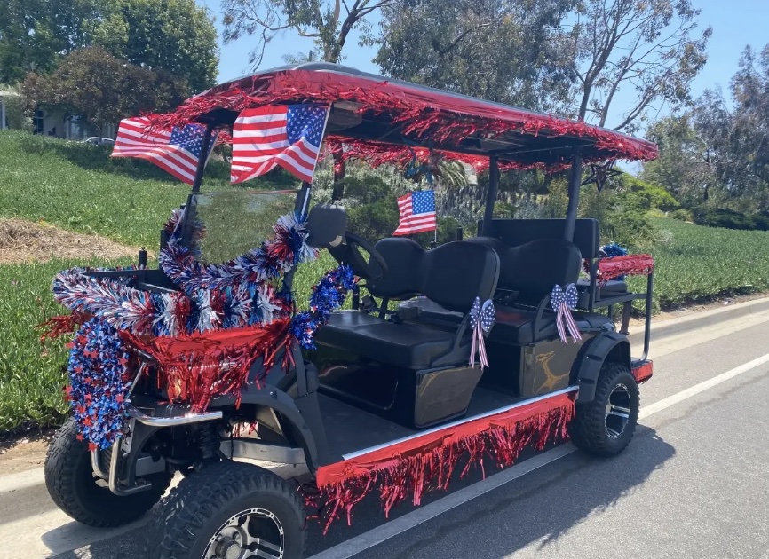 A golf cart decorated for a parade with colorful balloons and other decorations